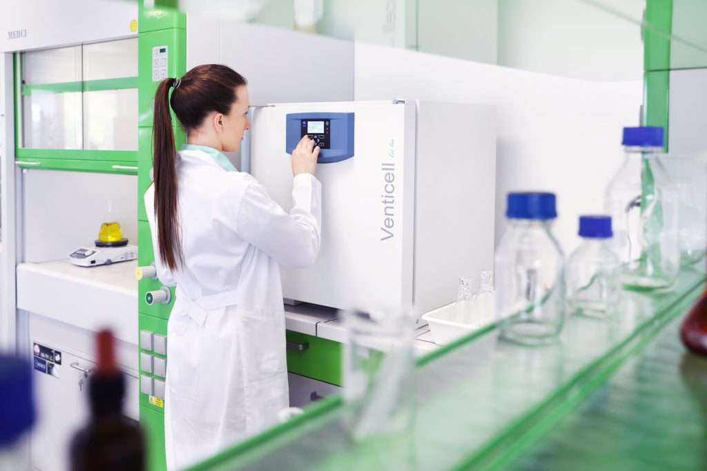 Laboratory tech interacting with a Venticell ECO forced air convection laboratory oven