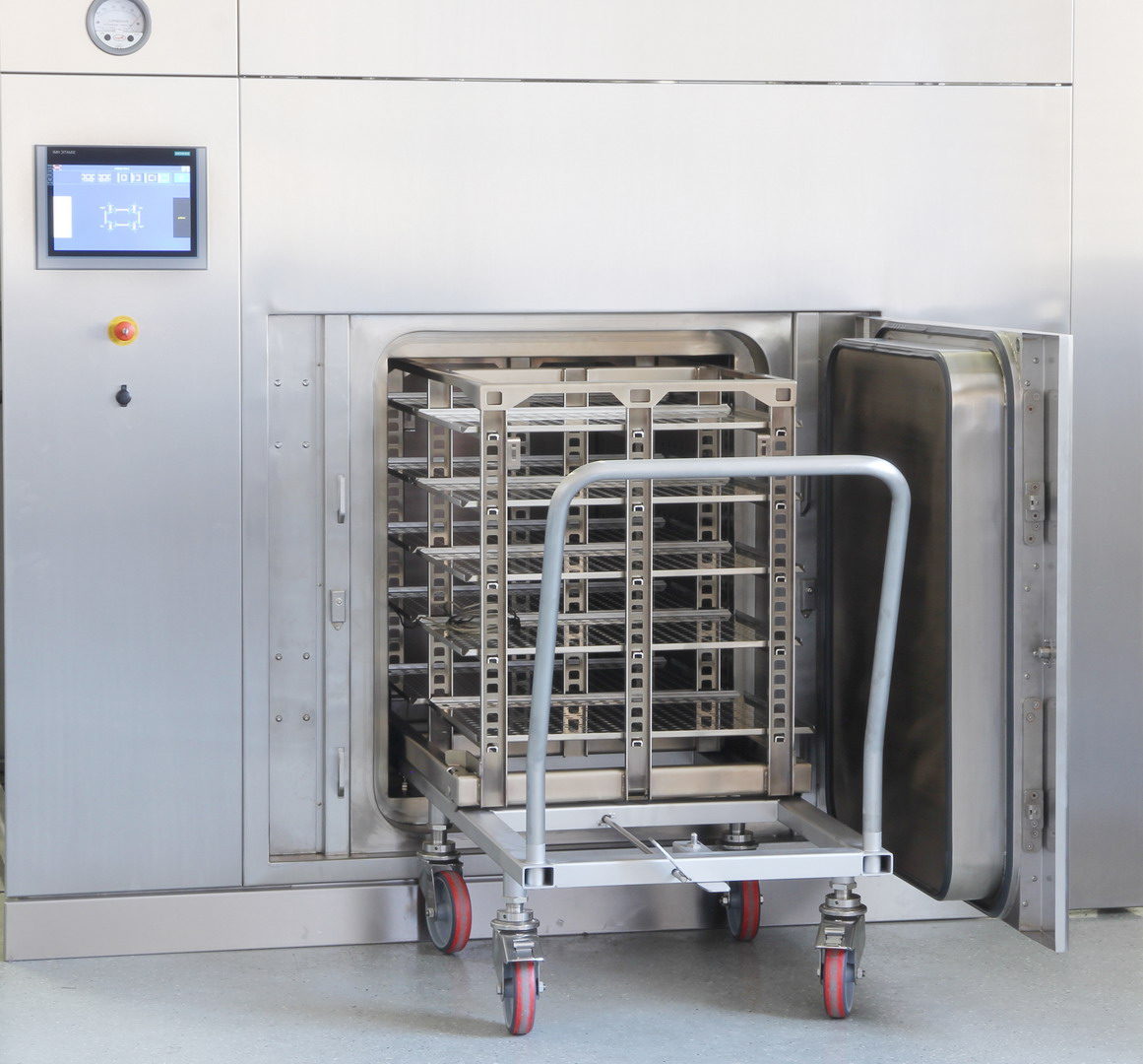 large depyrogenation oven with a transfer trolley and cart being loaded into the open chamber door